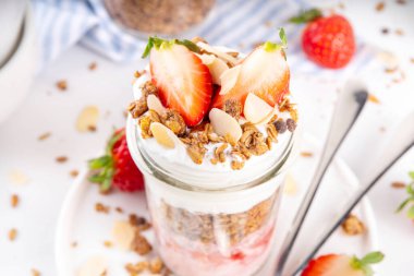 Çilek, Granola ve Yoğurt Kahvaltı Parfait. Çilek reçeli, kremalı Yunan yoğurdu, çikolatalı gevrek ve taze çilekli tatlı.