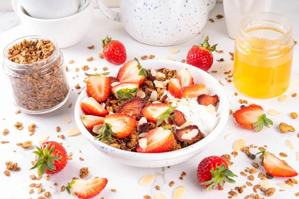 Sağlıklı yaz meyveli kahvaltı kasesi granola, kremalı Yunan yoğurdu ve çilekli. Lezzetli dengeli atıştırmalık, kilo kaybı, sağlıklı sabah yemeği tarifi.