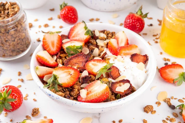 Sağlıklı yaz meyveli kahvaltı kasesi granola, kremalı Yunan yoğurdu ve çilekli. Lezzetli dengeli atıştırmalık, kilo kaybı, sağlıklı sabah yemeği tarifi.