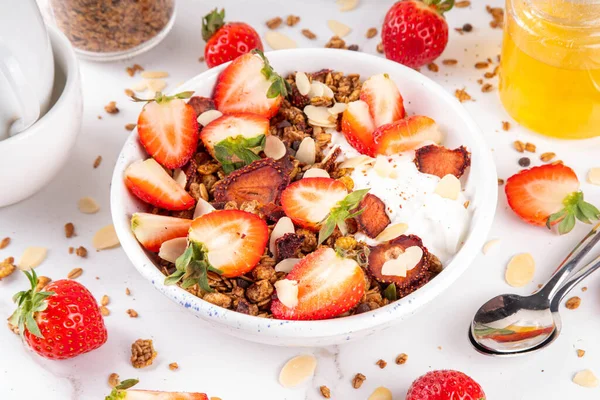 Sağlıklı yaz meyveli kahvaltı kasesi granola, kremalı Yunan yoğurdu ve çilekli. Lezzetli dengeli atıştırmalık, kilo kaybı, sağlıklı sabah yemeği tarifi.