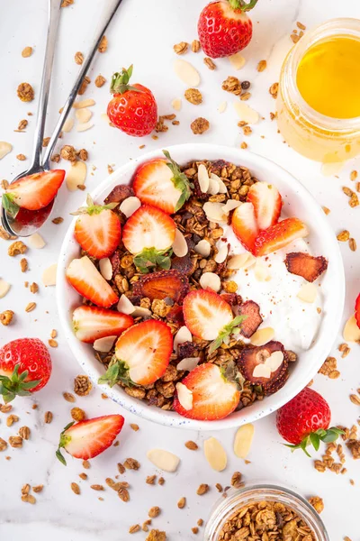 Sağlıklı yaz meyveli kahvaltı kasesi granola, kremalı Yunan yoğurdu ve çilekli. Lezzetli dengeli atıştırmalık, kilo kaybı, sağlıklı sabah yemeği tarifi.