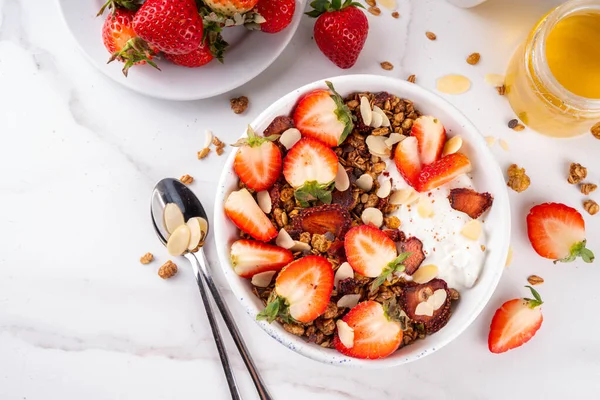 Sağlıklı yaz meyveli kahvaltı kasesi granola, kremalı Yunan yoğurdu ve çilekli. Lezzetli dengeli atıştırmalık, kilo kaybı, sağlıklı sabah yemeği tarifi.