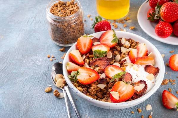 Sağlıklı yaz meyveli kahvaltı kasesi granola, kremalı Yunan yoğurdu ve çilekli. Lezzetli dengeli atıştırmalık, kilo kaybı, sağlıklı sabah yemeği tarifi.