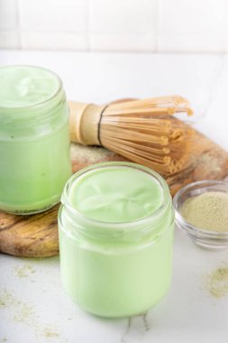 Küçük kavanozlarda kibrit yoğurdu, kibrit tozu ile vejetaryen ya da vejetaryen olmayan yoğurt, modaya uygun sağlıklı yiyecekler, kiraz çayı çırpma çırpma ve toz kopyalama alanı.