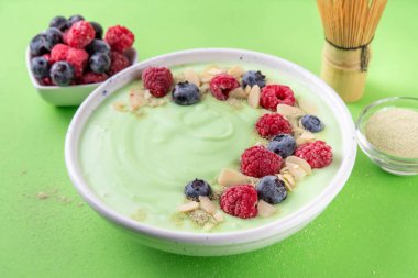 Yeşil kibrit yoğurt kasesi, taze böğürtlen, fındık ve granola. Sağlıklı kahvaltı için lezzetli, sağlıklı meyve suyu kasesi.