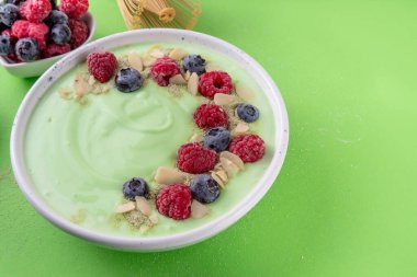 Yeşil kibrit yoğurt kasesi, taze böğürtlen, fındık ve granola. Sağlıklı kahvaltı için lezzetli, sağlıklı meyve suyu kasesi.