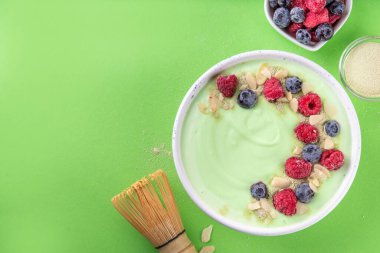 Yeşil kibrit yoğurt kasesi, taze böğürtlen, fındık ve granola. Sağlıklı kahvaltı için lezzetli, sağlıklı meyve suyu kasesi.