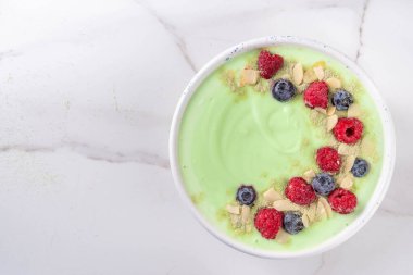 Yeşil kibrit yoğurt kasesi, taze böğürtlen, fındık ve granola. Sağlıklı kahvaltı için lezzetli, sağlıklı meyve suyu kasesi.