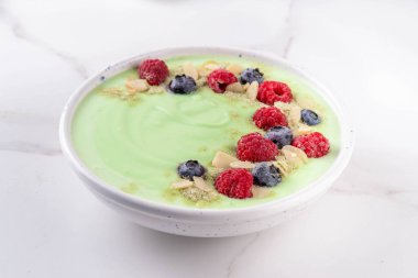 Yeşil kibrit yoğurt kasesi, taze böğürtlen, fındık ve granola. Sağlıklı kahvaltı için lezzetli, sağlıklı meyve suyu kasesi.