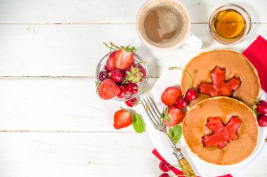 Kanada Günü konsepti, brunch menüsü geçmişi. Kırmızı ve beyaz krep yığını, akçaağaç yaprağı yaratıcı dekorasyonu, Kanada Günü kahvaltısı fikri.