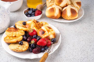 Paskalya yemeği fikirleri, sıcak haç çörekleri kahvaltıda yumurtalı ekmek. Paskalya artığı tarifi, sıcak haç çörekleri ve taze böğürtlenlerle yapılmış fırında pişmiş Fransız tostu, fotokopi alanı.