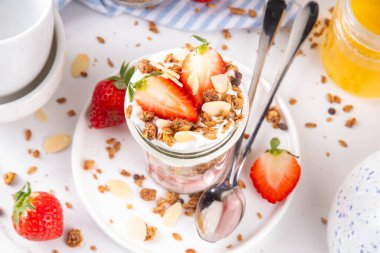 Çilek, Granola ve Yoğurt Kahvaltı Parfait. Çilek reçeli, kremalı Yunan yoğurdu, çikolatalı gevrek ve taze çilekli tatlı.