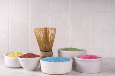 Beyaz kasede kurutulmuş kibrit tozu seti. Çeşitli renkler ve özetler eşleşiyor - yeşil, sarı, pembe, kırmızı, beyaz arka planda meyveli sağlıklı eşleşen çay içecekleri yapmak için.