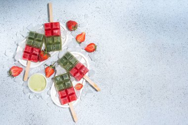 Sütsüz yeşil kibrit ve çilekli dondurma. Yeşil kibrit çay tozu ve dut suyu ile vejetaryen dondurması, beyaz beton arka planda sağlıklı organik tatlı.