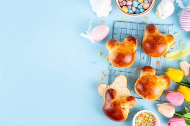 Paskalya bayramında kahvaltı ya da atıştırmalık tatlı bir fikir. Tavşan suratlı lezzetli çörekler çikolatalı yumurtalar ve paskalya dekoruyla