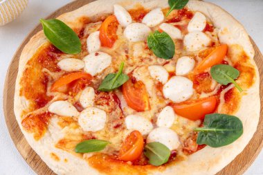 Mozarella peynirinden yapılmış tavşan yüzlü Paskalya pizzası. Kiraz domatesli, peynirli ve taze ıspanaklı pizza margherita bayram kahvaltısı veya parti için yaratıcı bir fikir.