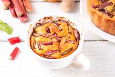 Yaz ev yapımı pişirme, hızlı mikrodalga fırın kek, mugcake. Basit tatlı mevsimlik tatlı tarifi, üstünde ravent dilimleri ve içinde tatlı reçel olan sünger keki.