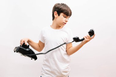 Çocuk klasik telefona bakıyor.