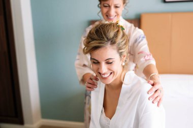 Evlenmeden önce, evlendiği gün beyaz giysili güzel sarışın kadın, giyinmesine yardım ediyor..