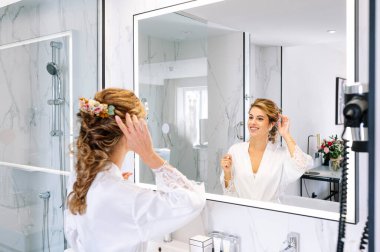 Güzel bir kadın aynaya makyaj yapıyor.