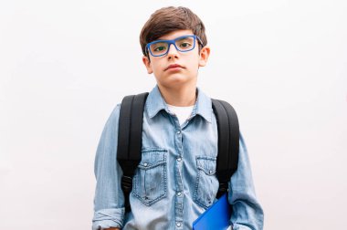 Gözlüklü ve sırt çantalı güzel çocuk izole edilmiş beyaz arka plan kitapları tutuyor.