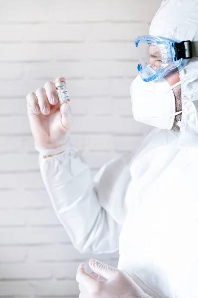 Verpleegster Beschermingspak Kijkt Naar Injectieflacon Met Vaccin Tegen Covid19 — Stockfoto