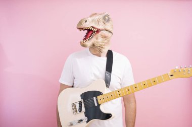 Kertenkele maskeli ve elektro gitarlı bir adam.