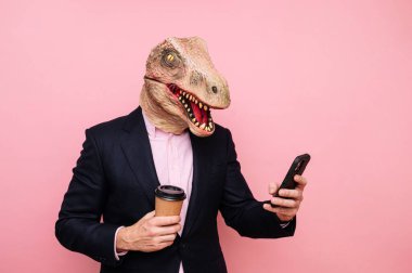 Kertenkele kafalı, elinde geri dönüşümlü karton kahve ve akıllı telefon olan adam..