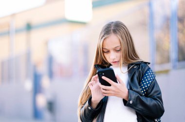 Akıllı bir telefonla okula giden öğrenci kız.