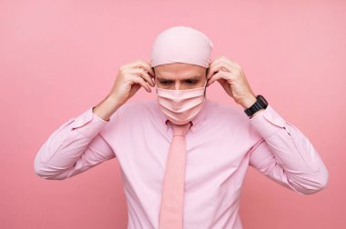 Fularlı ve pembe maskeli adam, kanserle dayanışma içinde.