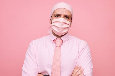 Fularlı ve pembe maskeli adam, kanserle dayanışma içinde.