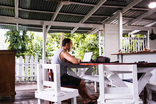 Digital nomad man working in a cabin in the jungle