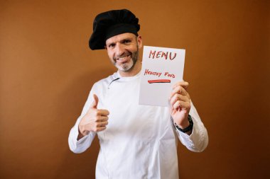 Şef elinde menü yazan bir tabela tutuyor.
