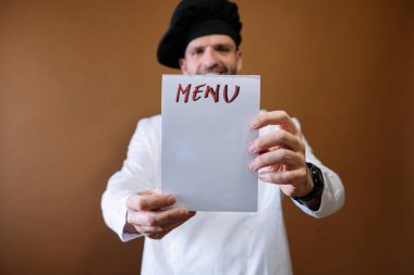 Şef elinde menü yazan bir tabela tutuyor.