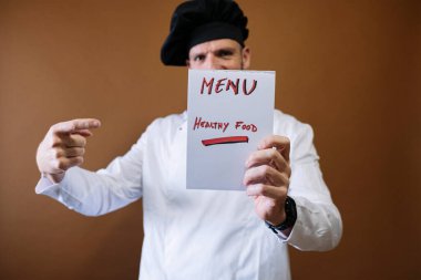 Şef elinde menü yazan bir tabela tutuyor.