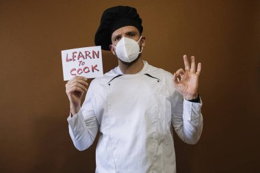 Yüz maskeli bir erkek aşçı ve 