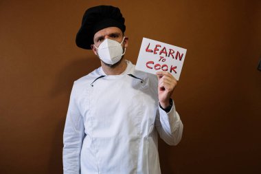 Yüz maskeli bir erkek aşçı ve 