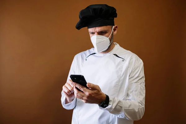 Koki Pria Dengan Masker Wajah Menggunakan Smartphone — Stok Foto