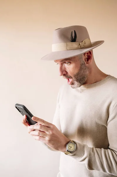 Έκπληκτος Άνθρωπος Καπέλο Χρησιμοποιώντας Έξυπνο Τηλέφωνο Εσωτερικούς Χώρους — Φωτογραφία Αρχείου