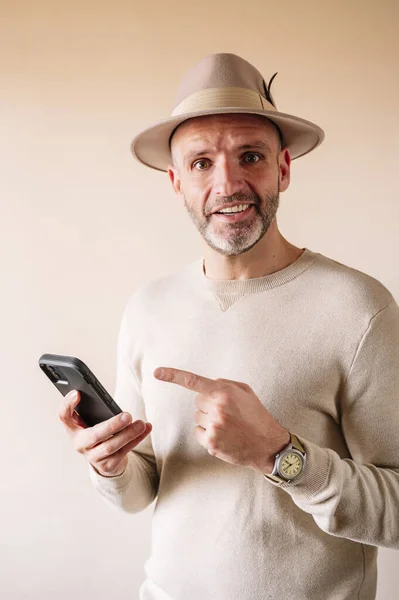 Άνθρωπος Καπέλο Που Δείχνει Δάχτυλο Έξυπνο Τηλέφωνο Εσωτερικούς Χώρους — Φωτογραφία Αρχείου