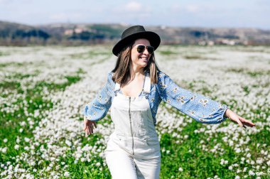 Çiçek tarlasında koşan mutlu kadın