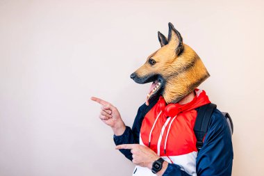 Kertenkele kafalı ve parmaklarını yana doğru gösteren bir adam..