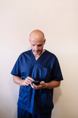 Stüdyo portresi, gülümseyen doktor ve akıllı telefon sağlık çalışanı.