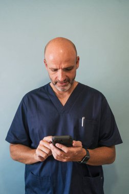 Stüdyo portresi, gülümseyen doktor ve akıllı telefon sağlık çalışanı.