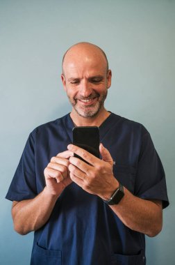 Stüdyo portresi, gülümseyen doktor ve akıllı telefon sağlık çalışanı.