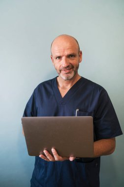 Studio portrait of smiling doctor with laptop healthcare worker