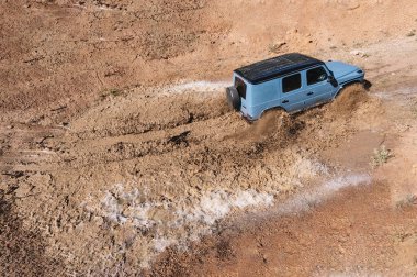 4x4 vehicle in full action going through a large puddle of water and mud. Concept of movement and energy