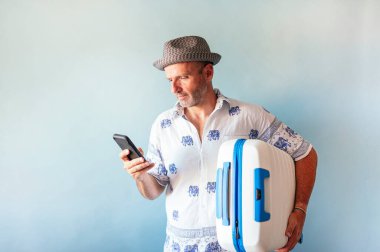 Yaz tatilinde bavullu akıllı telefon kullanan adamlar..