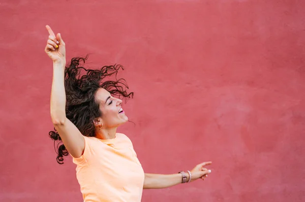 Mujer Alegre Bailando Con Los Brazos Levantados Frente Pared — Foto de Stock