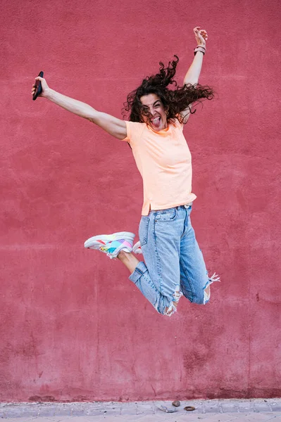 Mujer Feliz Con Gafas Sol Saltando Frente Pared Roja — Foto de Stock
